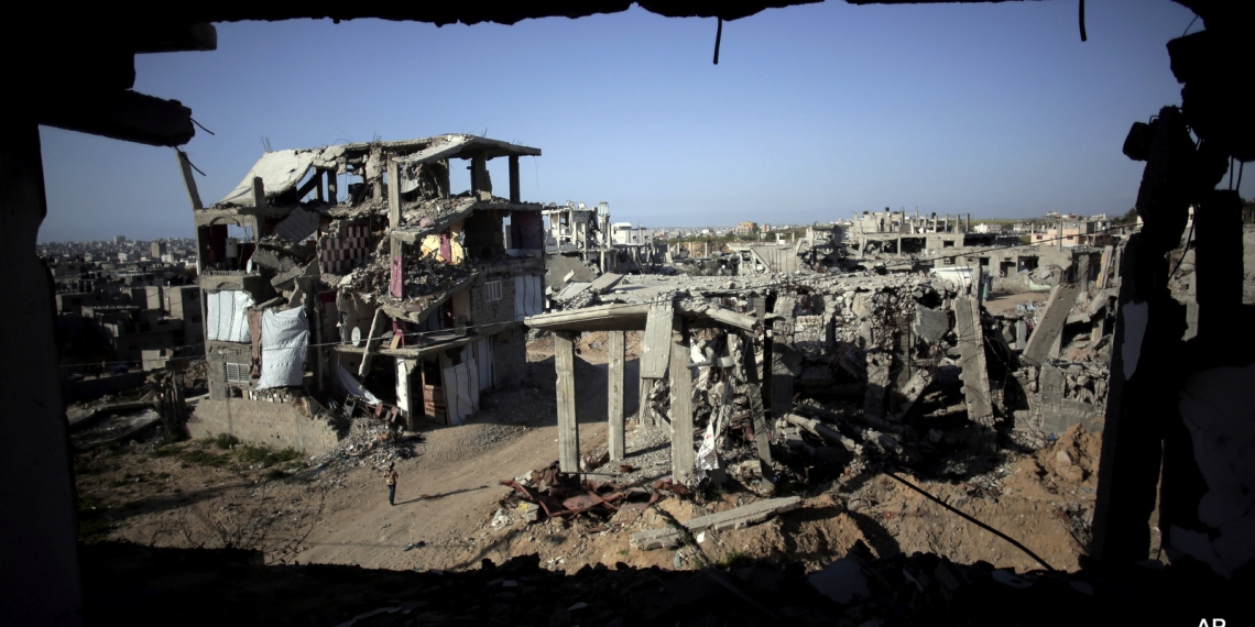 File - In this March 30, 2015 file photo, a Palestinian girl walks next to destroyed houses, in the Shijaiyah neighborhood of Gaza City. The International Monetary Fund said in a Tuesday, May, 19, 2015 report, that reconstruction of the Gaza Strip is going “far more slowly than expected” after a devastating war between Israel and the Hamas militant group last year. The IMF said that just over a quarter of $3.5 billion pledged for reconstruction has been disbursed and urged donors to fulfill their pledges.  (AP Photo/Khalil Hamra, File)