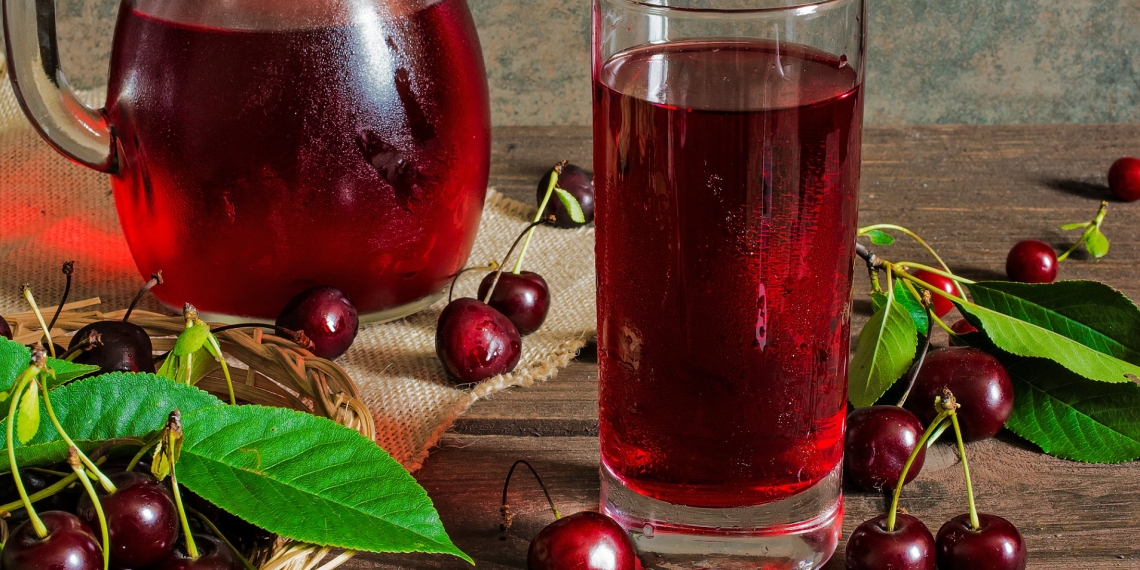 cold cherry juice in a glass and pitcher on wooden table with ripe berries in wicker basket; Shutterstock ID 447393178; Purchase Order: -